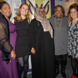 A group of women standing together, smiling and posing for a photo