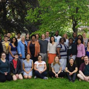 A large group of people gather for a photo on the grass