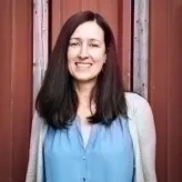 photo of a brunette woman wearing a powder blue blouse with a big smile