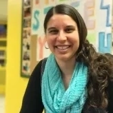 Picture of Julia, a woman with brown hair, wearing a turquoise scarf