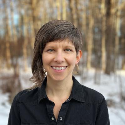 portrait of tyler kidder wearing a black shirt with a snowy woodland background